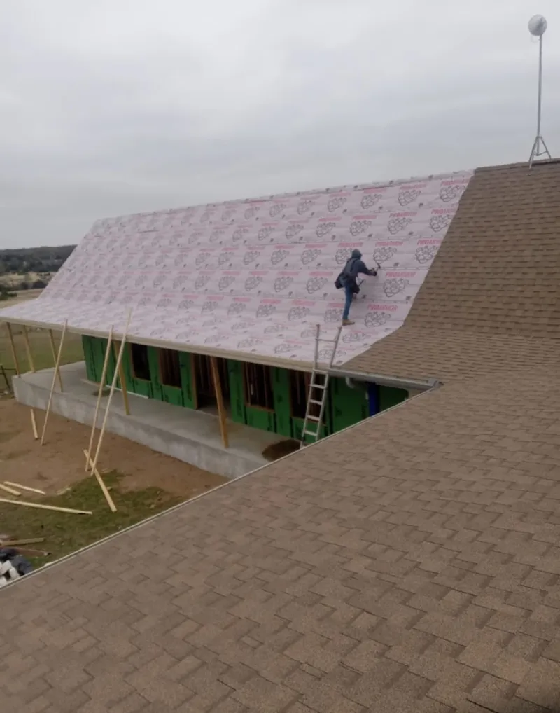 Worker preparing underlayment for a metal roof installation in Northumberland